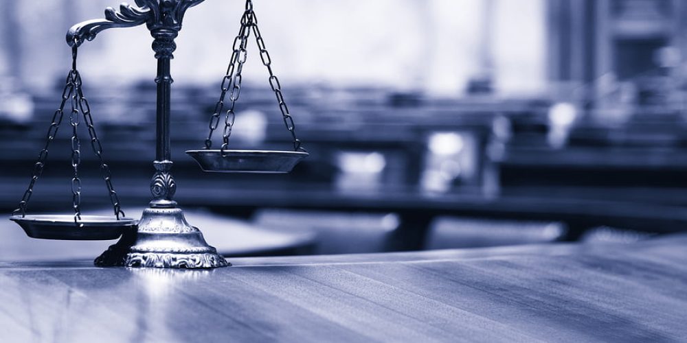 Symbol of law and justice in the empty courtroom law and justice concept blue toned.